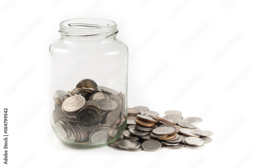 coins in a glass jar against a white background coins in a glass jar against a white background