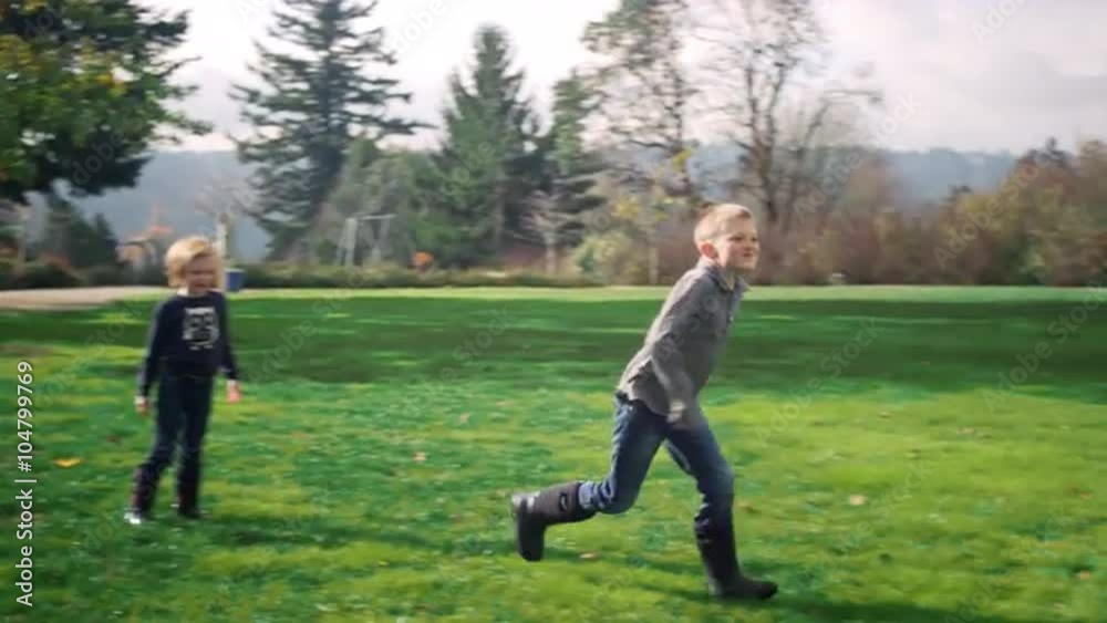 Siblings fighting and then running down a path at a park, in slow motion Siblings fighting and then running down a path at a park, in slow motion