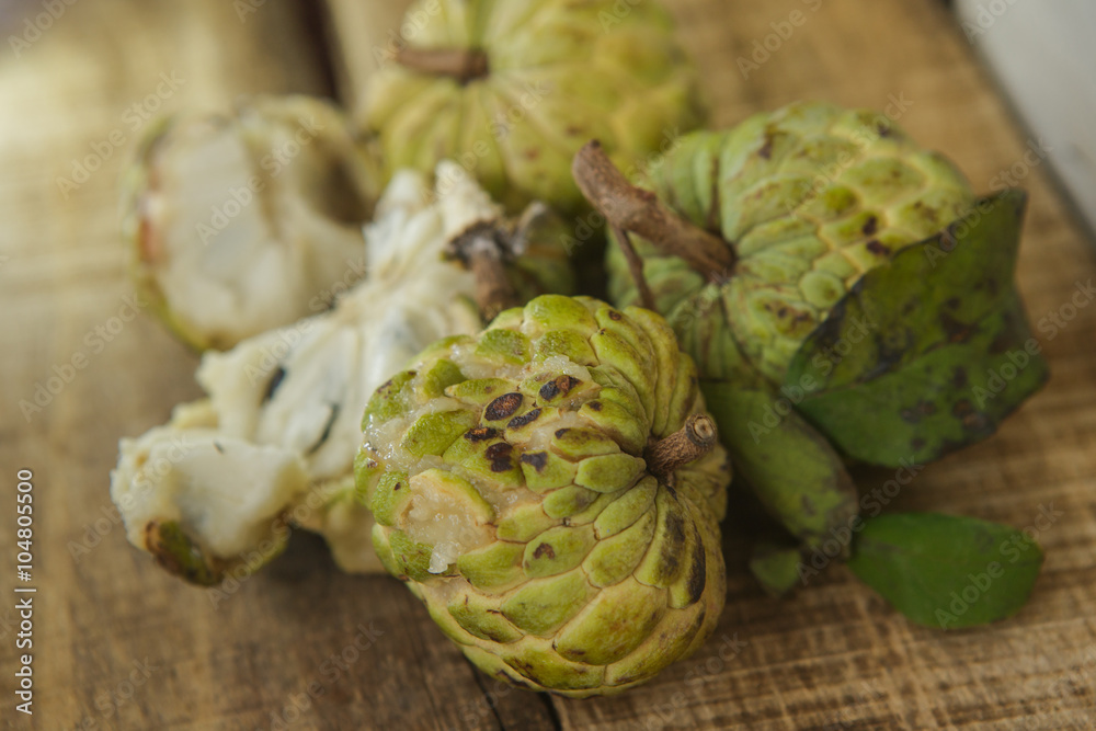 Obraz premium Closeup Broken and Unbroken Ripe Sugar-apples on Table