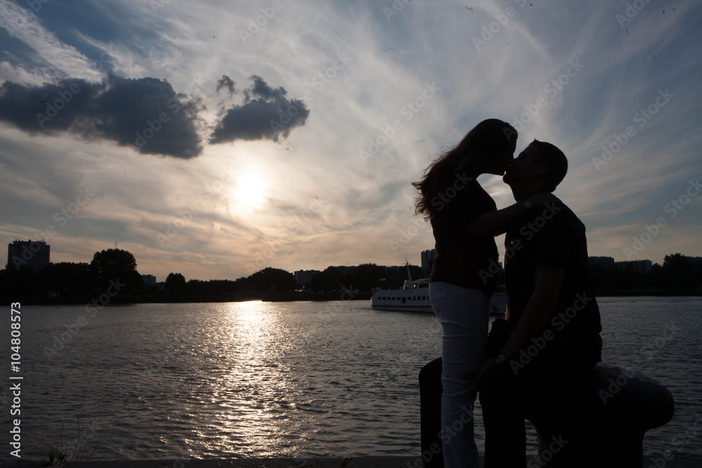 Silhouette of a romantic couple against a vivid sunset
