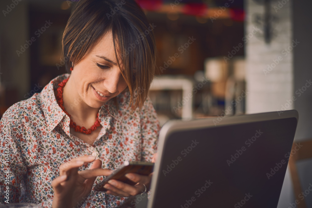 Beautiful young Caucasian girl working at a coffee shop with a laptop.female freelancer connecting to internet via computer.
