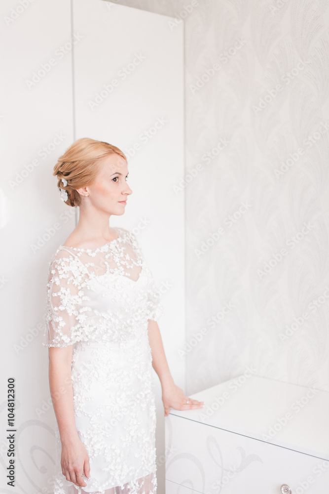Gorgeous bride with wedding bouquet makeup and hairstyle in bridal dress at home waiting for groom. Gorgeous bride with wedding bouquet makeup and hairstyle in bridal dress at home waiting for groom.
