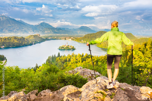 Young spoty active lady with hiking sticks admiring beautiful nature around Bled Lake in Julian Alps, Slovenia.  photo
