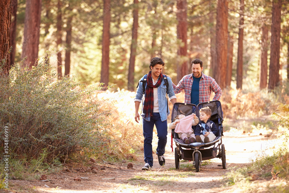 Gay Male Couple Pushing Children In Buggy Through Woods