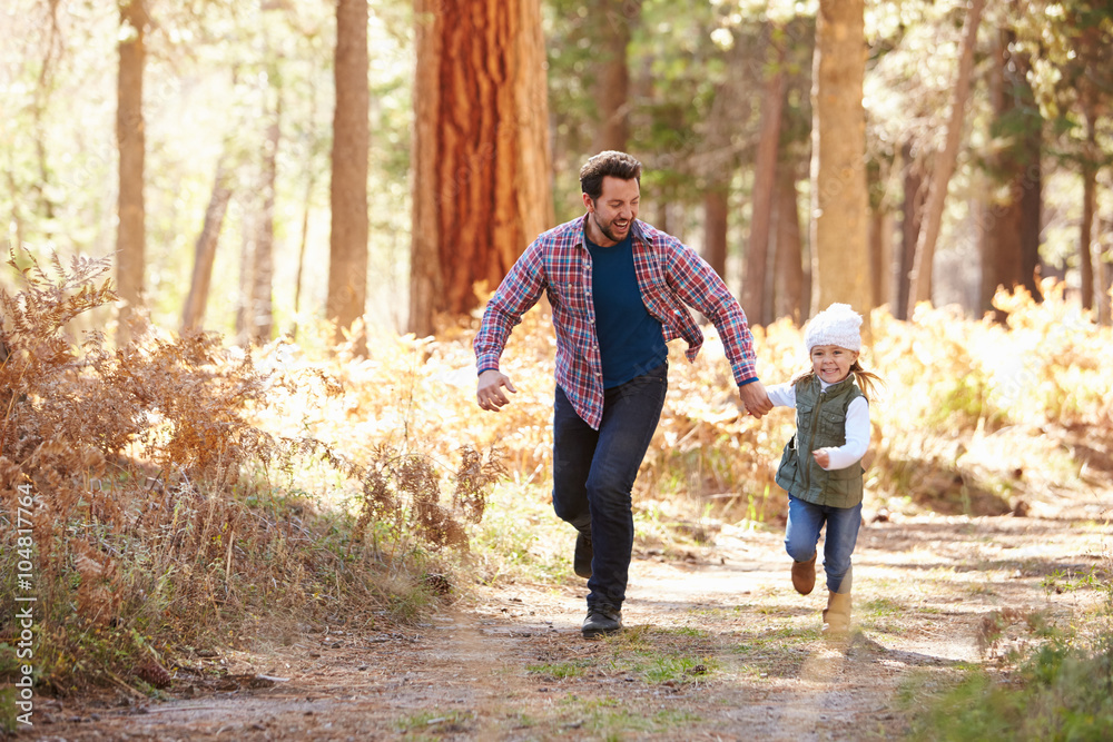 Father And Daughter Running Through Fall Woodland Father And Daughter Running Through Fall Woodland