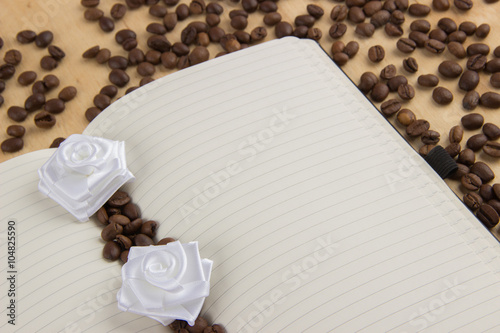 Open notebook with lined pages on a table on which are scattered