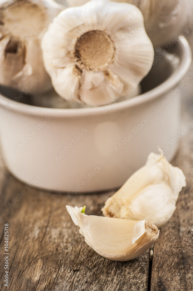Composition of garlic and rosemary on wooden background, close up Composition of garlic and rosemary on wooden background, close up