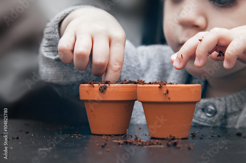Child planting seeds in pots