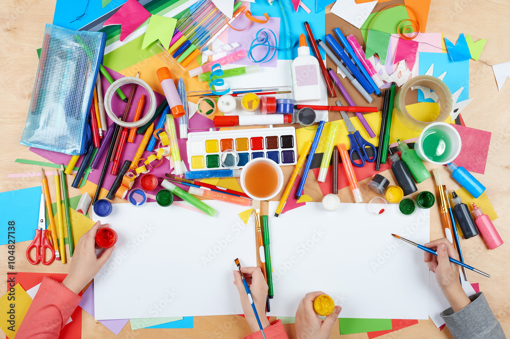 Naklejka premium Child drawing top view. Artwork workplace with creative accessories. Flat lay art tools for painting.
