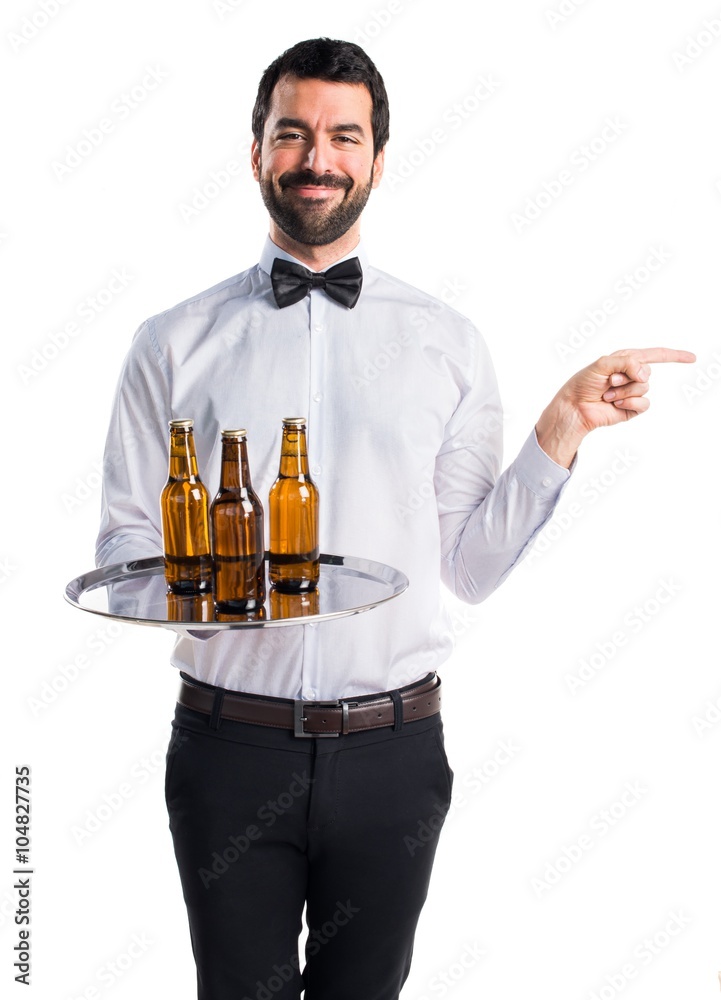 Waiter with beer bottles on the tray pointing to the lateral