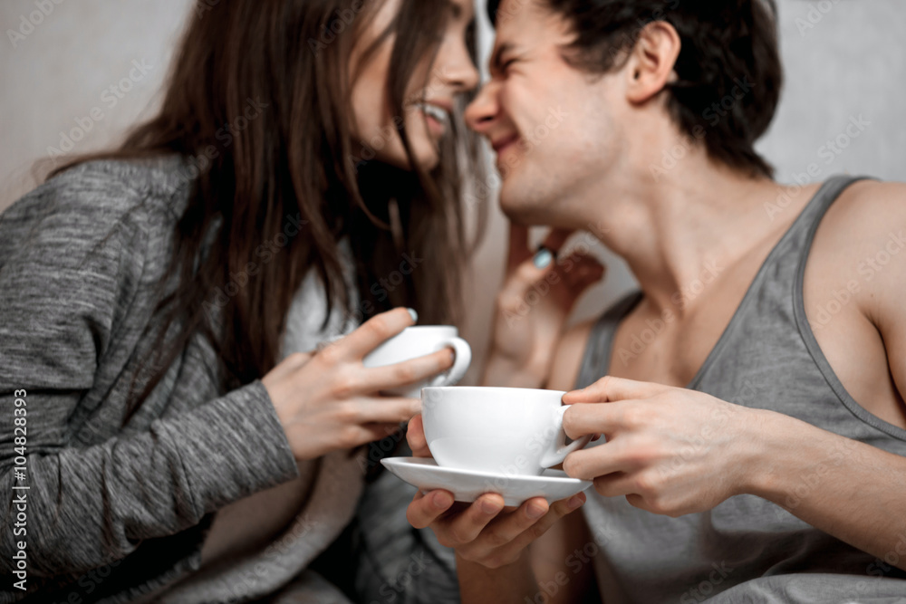 Young beautiful pair of lovers drink tea (coffee) in bed Young beautiful pair of lovers drink tea (coffee) in bed