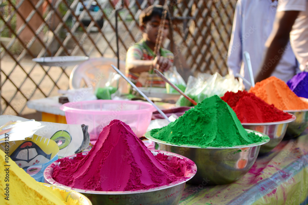 Colors of India. Colorful powders used for religious purposes by Indian people in a special packet. Child is selling colors.