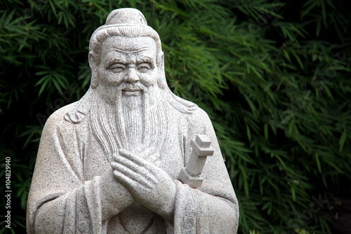 Chinese statue of Confucius with bamboo leaves background