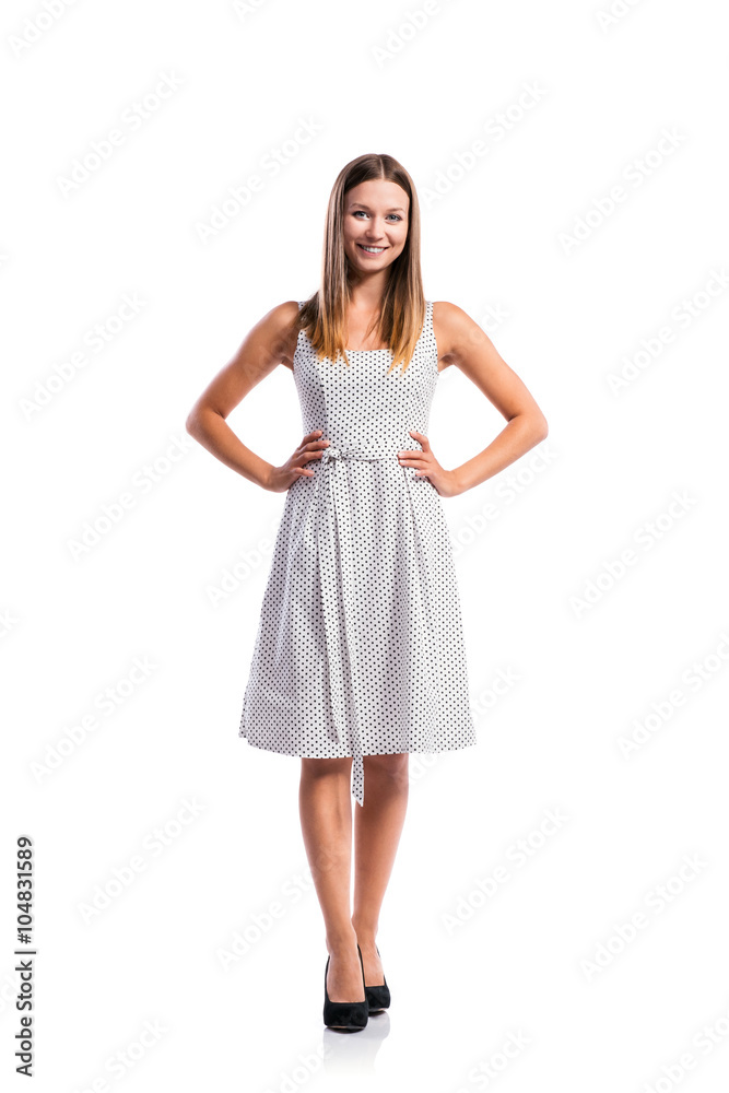 Girl in black-and-white dotted dress, heels, studio shot, isolat