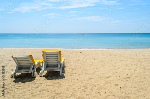 Beach chairs on White Sand Beach with blue sky in Phuket Thailand