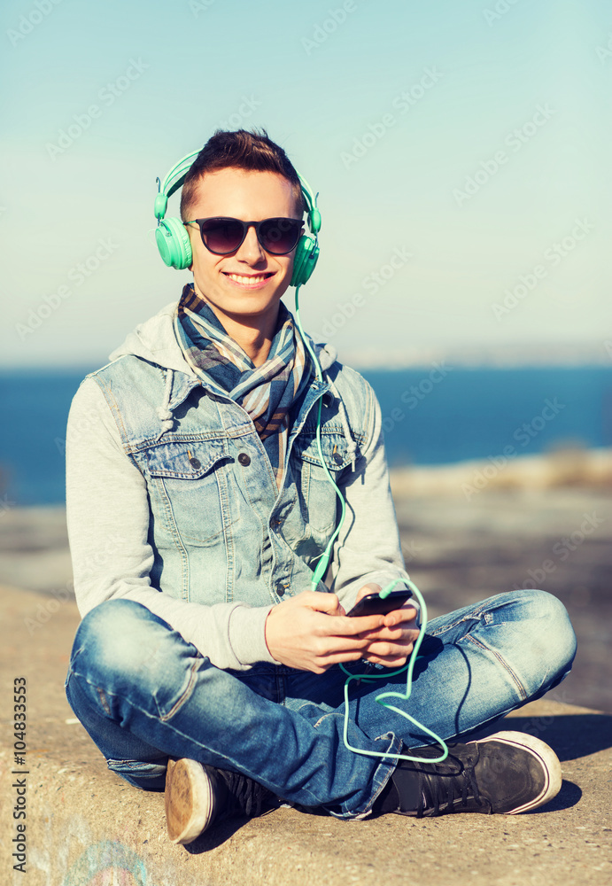 happy young man in headphones with smartphone
