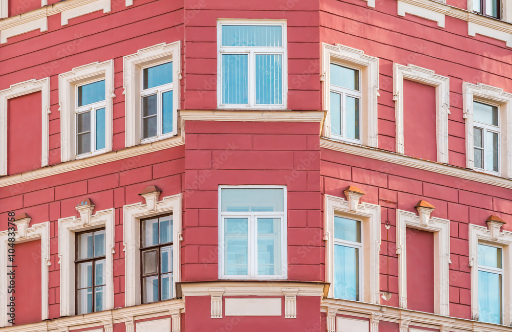 Several windows in row on corner of facade of urban apartment building front view, St. Petersburg, Russia.
