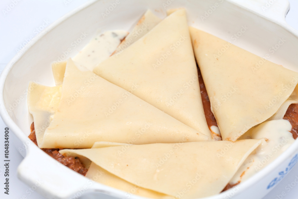 Triángulos rellenos para la lasagna parmesana en molde con salsa bolognesa