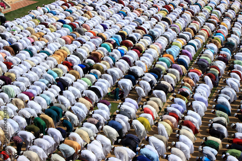 Muslim prayer. A group of Muslim are praying. They wear-ed different color dress.