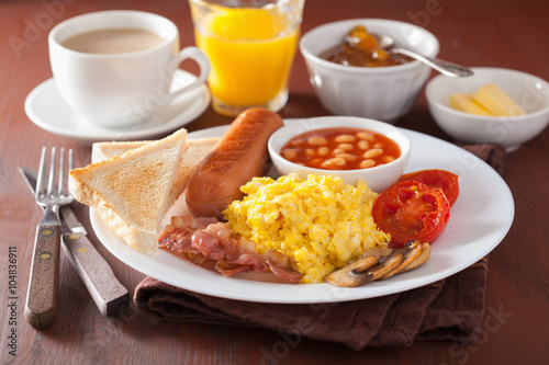 full english breakfast with scrambled eggs, bacon, sausage, bean