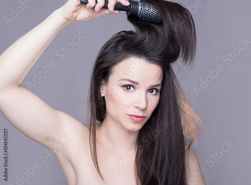 Brunette girl brushing her hair 