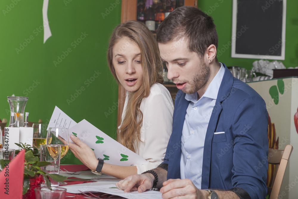 Naklejka premium Paar ist überrascht über die hohen Preise in der Speisekarte