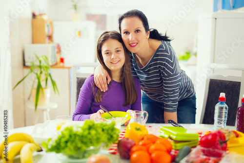 Mother making breakfast for her children in the morning and a sn