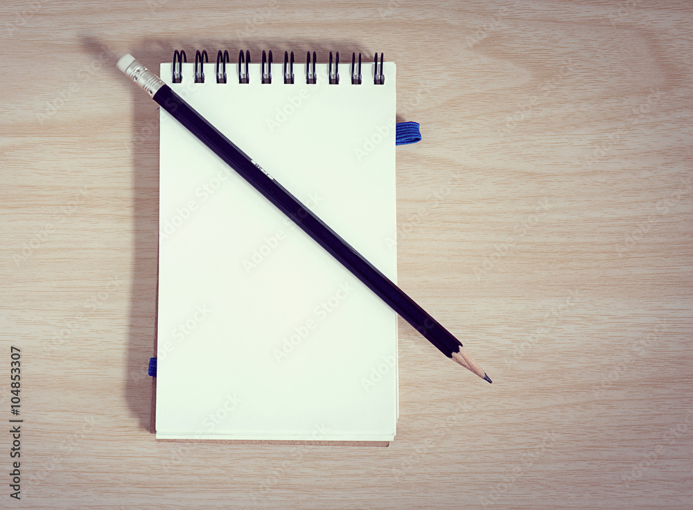 notebook with a pencil on wooden background