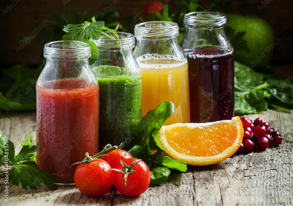 Bottles with fresh juices from fruits and vegetables on an old w Bottles with fresh juices from fruits and vegetables on an old w