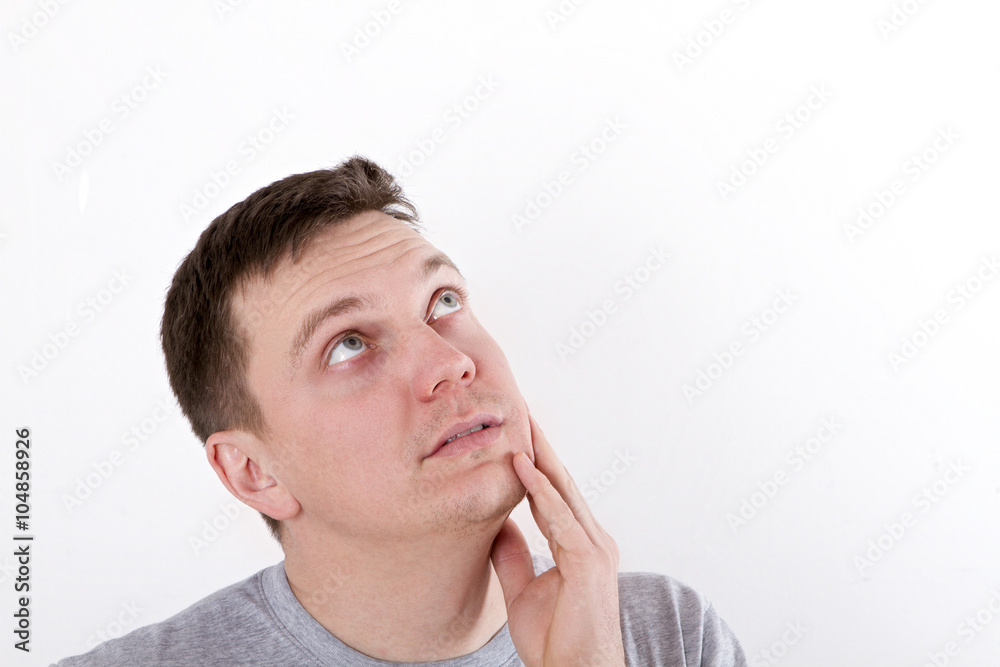 Thinking man isolated on white background. Closeup portrait of a casual young pensive man looking up at copyspace. Caucasian male model. Thinking man isolated on white background. Closeup portrait of a casual young pensive man looking up at copyspace. Caucasian male model.