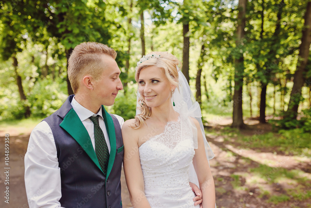 Young wedding couple enjoying romantic moments outside on a summer meadow