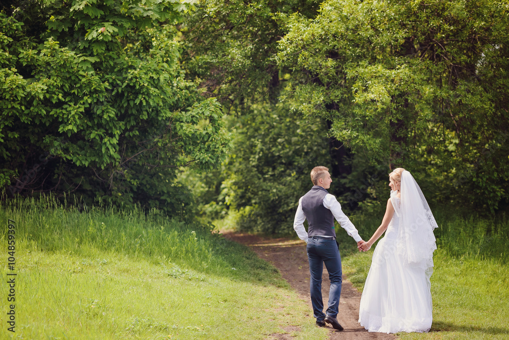 Fototapeta premium Young wedding couple enjoying romantic moments outside on a summer meadow