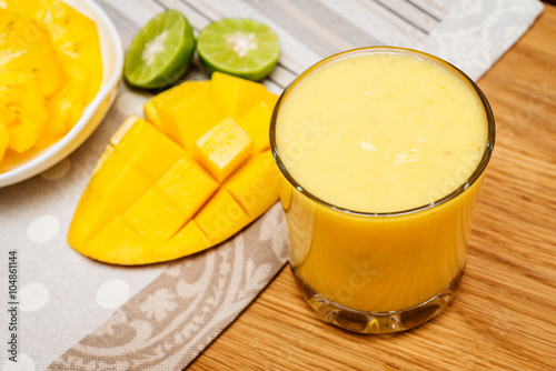 Smoothies mango and yogurt in a glass  on wooden background.