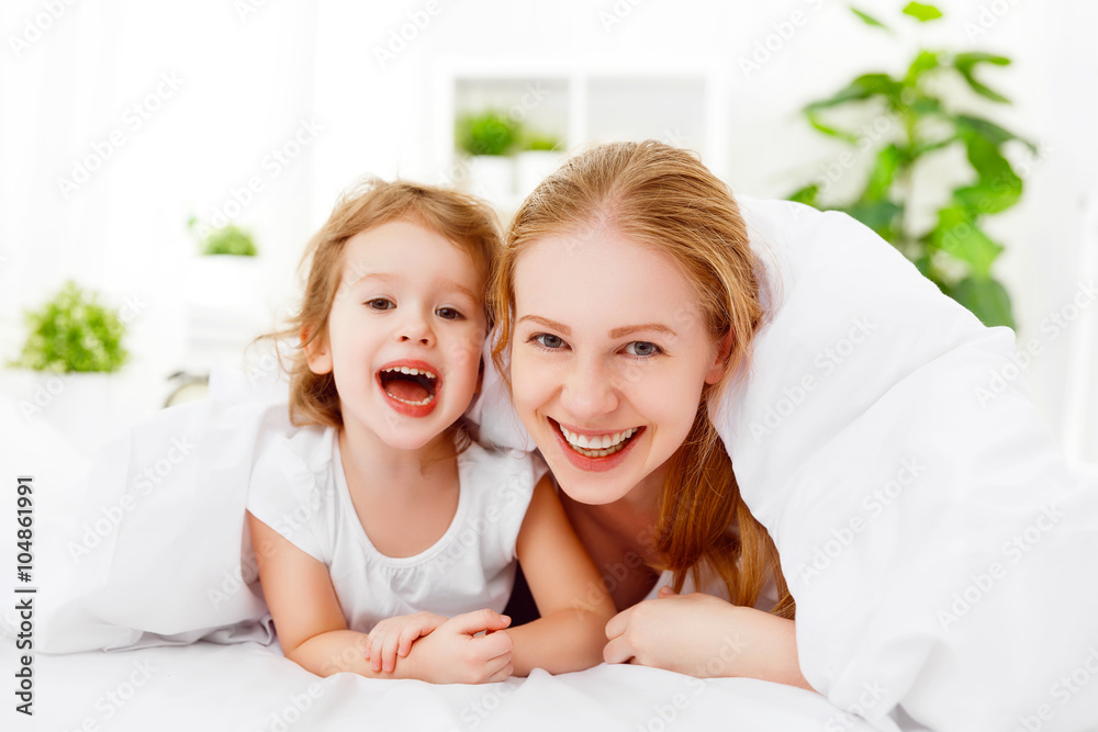 happy family mother and child playing and laughing in bed happy family mother and child playing and laughing in bed