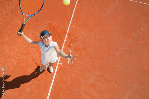 Tennis serve. Junior level player in action, viewed from above © Microgen