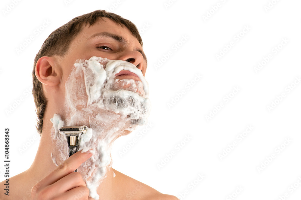 portrait of young caucasian male in shaving foam shaving sharp razor neck