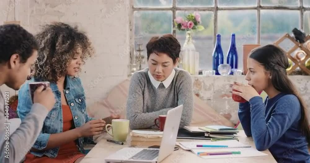 Diverse group of students studying at home using books and laptop technology