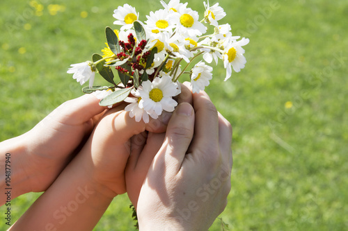 Mother and your child holding a beatiful spring flower bouquet.