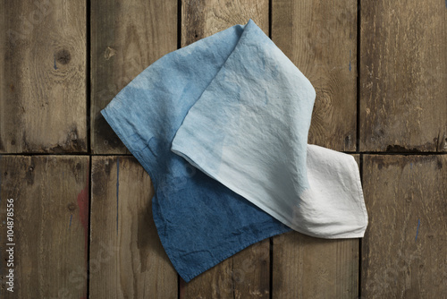 Folded Gradient Blue Cloth or Linen on Wooden Panel Surface