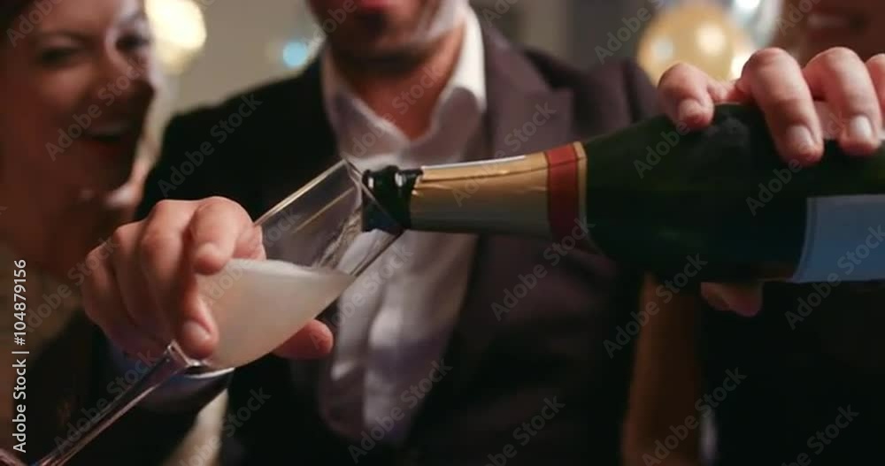 Friends holding up champagne flutes together in a toast at party