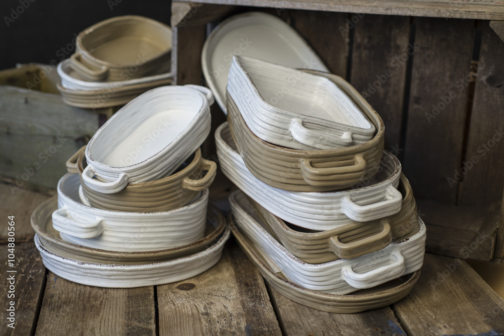 Stacks of White and Tan-Colored Earthenware with Handles Facing