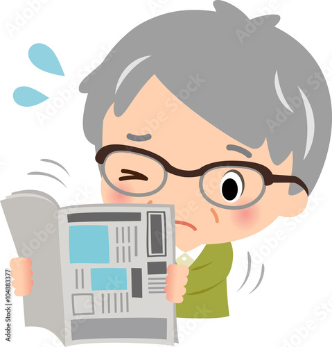 新聞を読む老眼の高齢男性