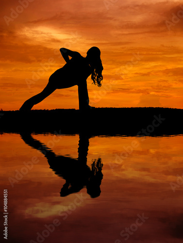 Fototapeta Naklejka Na Ścianę i Meble -  Silhouette of a beautiful Yoga woman with water reflection