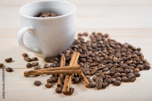 coffee beans in cup. Coffee cup and coffee beans on wooden background. coffee with cinnamon, coffee with additives 