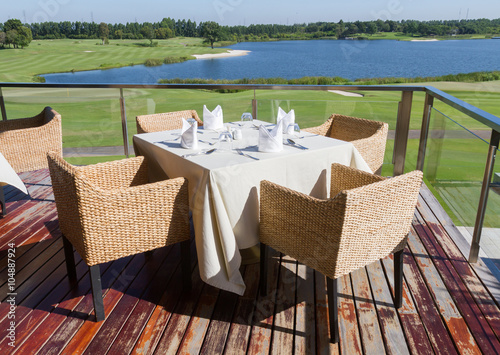 Table on terrace for eat foods at clubhouse in golf course. photo
