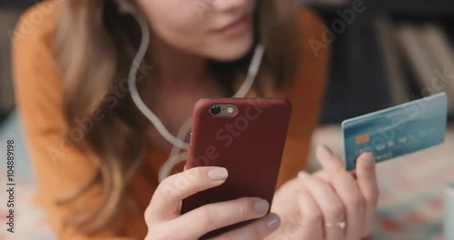Beautiful woman shopping online with credit card and smart phone at home in trendy loft apartment