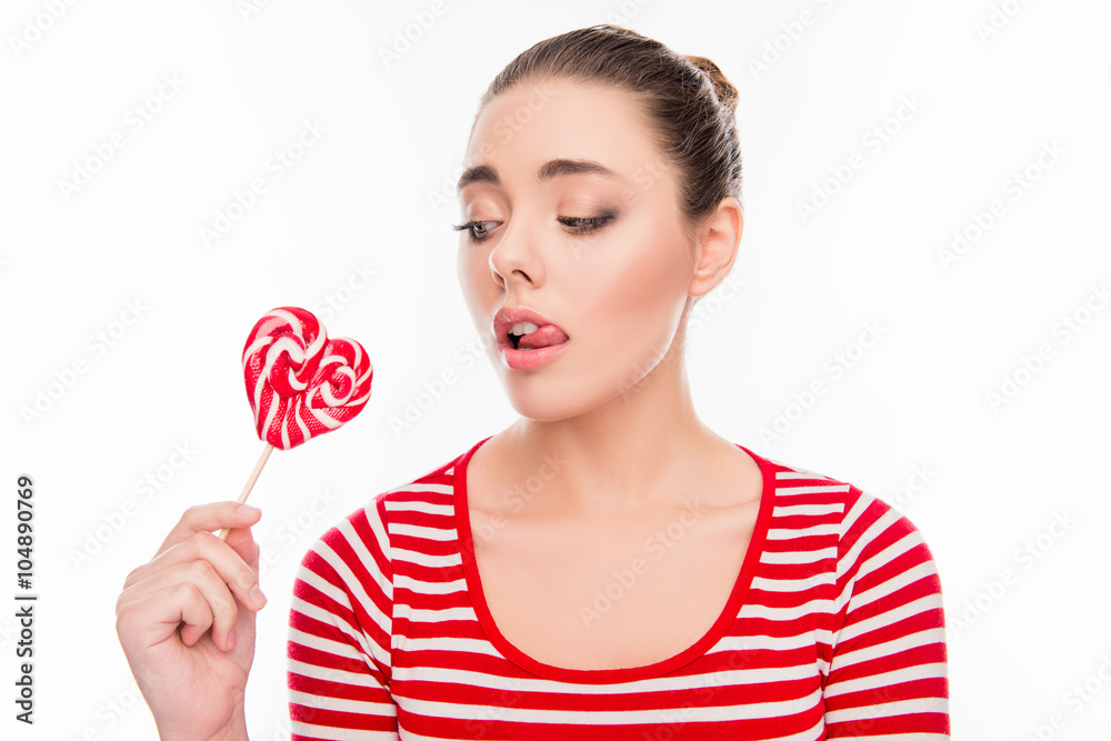 Pretty young woman holding lollipop and licking her lips