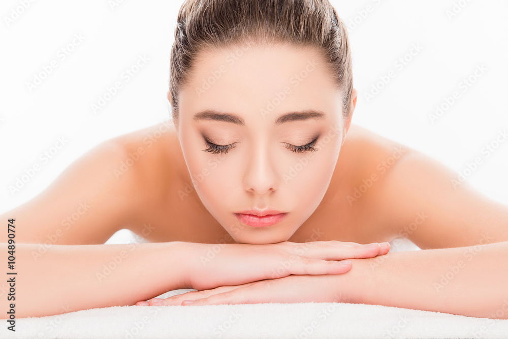 Attractive woman lying in spa salon with closed eyes and relaxin Attractive woman lying in spa salon with closed eyes and relaxin