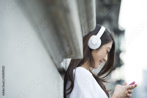 Young woman listening to music with a headphone #104891120