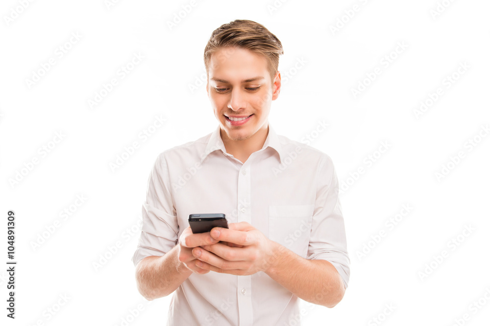 Young cheerful businessman typing sms on his mobile phone Young cheerful businessman typing sms on his mobile phone